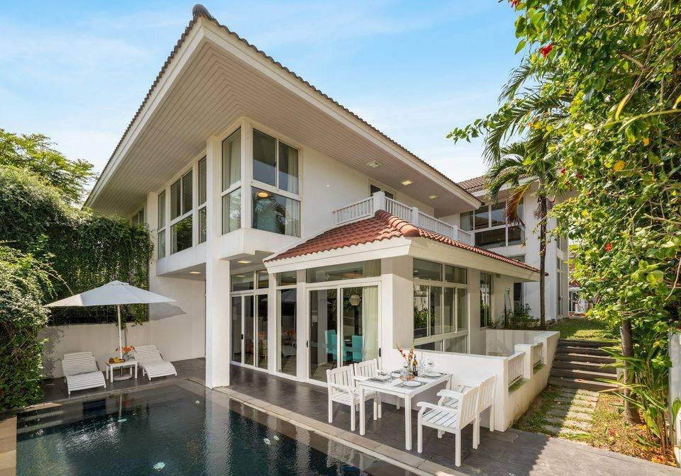 A white vacation-style home with a pool and outdoor seating